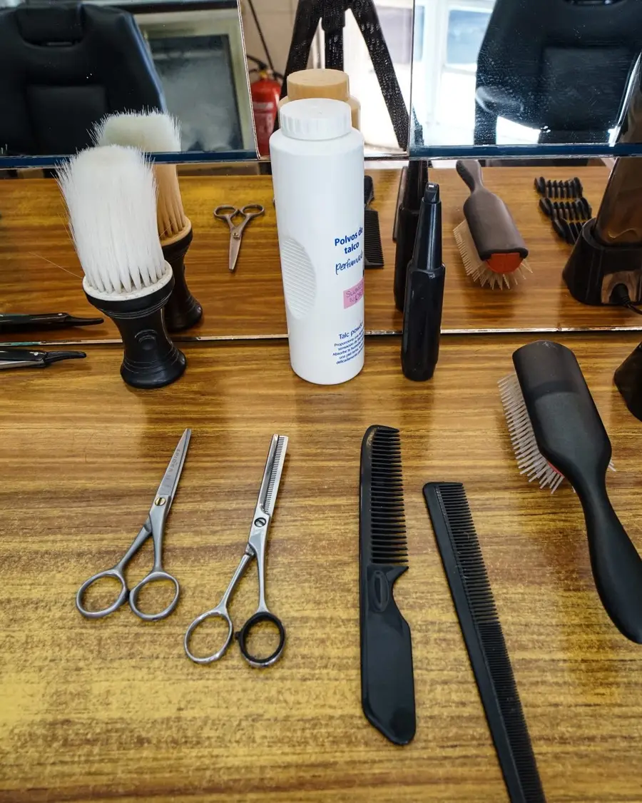 Scissors, combs and clippers laid out on a salon counter