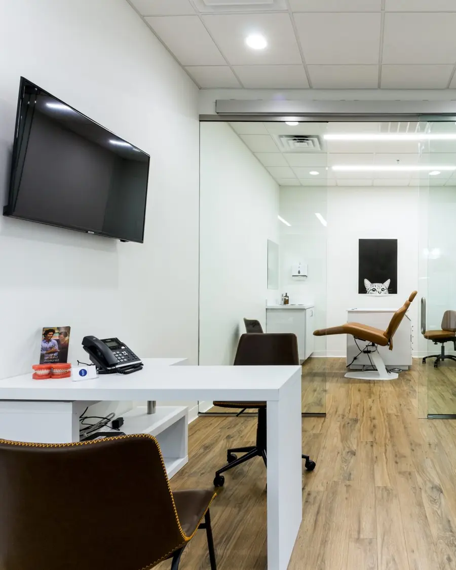 A bright clinic waiting room with a TV on the wall